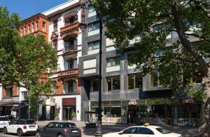 eine Straße mit Autos, die vor einem Gebäude geparkt sind in der Unterkunft Leonardo Hotel Berlin KU'DAMM in Berlin