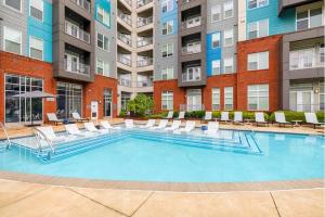a large swimming pool with chairs and a building at 5-Bedroom Combined Apartment in King of Prussia! in King of Prussia