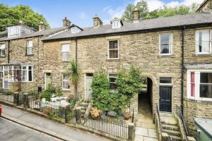 une maison en briques avec une clôture devant elle dans l'établissement Homely 4 bed cottage central characterful, à Pateley Bridge