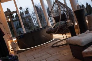 a porch with a hammock and a chair in a room at 5 Sterne Centurion Ferienhaus Villa 2 Pools 86 Zoll TV in Aldersbach