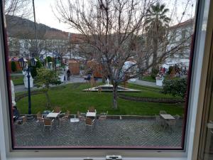 a view from a window of a park with tables and chairs at Garden House Fundão - Apartamento 201 com 2 quartos com vista jardim in Fundão