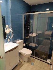 a bathroom with a toilet and a shower and a sink at Garden House Fundão - Apartamento 201 com 2 quartos com vista jardim in Fundão