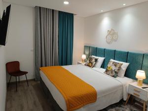una camera con un grande letto con testiera blu di Garden House Fundão - Apartamento 201 com 2 quartos com vista jardim a Fundão