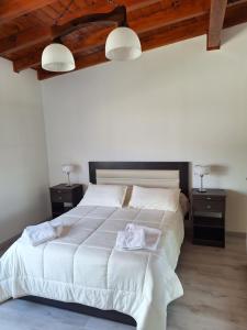 um quarto com uma grande cama branca com duas mesas de cabeceira em Cordillera sur em Esquel