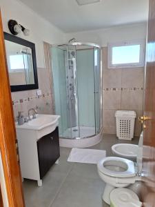 uma casa de banho com um chuveiro, um WC e um lavatório. em Cordillera sur em Esquel
