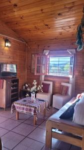 una sala de estar con una mesa en una cabaña de madera en La Inesita en Tafí del Valle