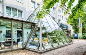 a glass building in front of a building at Leonardo Boutique Hotel Berlin City South in Berlin