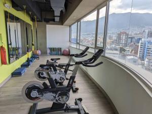 um ginásio com uma fila de bicicletas de exercício num edifício em Suite studio Ph - Metro la Carolina em Quito