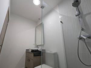 a white bathroom with a shower and a toilet at Suite studio Ph - Metro la Carolina in Quito +17 photos