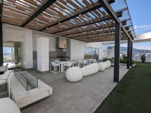 a patio with white chairs and a table on a roof at Suite studio Ph - Metro la Carolina in Quito