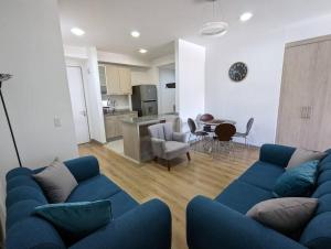 a living room with a blue couch and a kitchen at Suite studio Ph - Metro la Carolina in Quito