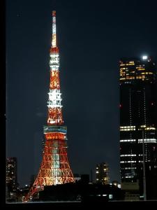 a lit up eiffel tower in a city at night at Henn na Hotel Tokyo Hamamatsucho in Tokyo