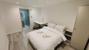 a bedroom with a white bed with two candles on it at flat 2 Wimbledon in London