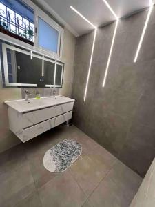 ein Bad mit einem Waschbecken und einer Dusche mit einem Fenster in der Unterkunft Magnifique Villa avec garage à 2min de la plage Saint-Rock, Ain El Turk, Oran in Aïn El Turk