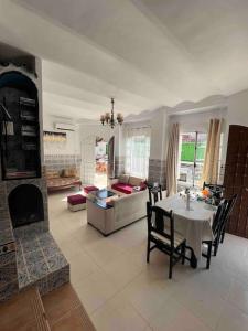 ein Wohnzimmer mit einem Tisch und einem Kamin in der Unterkunft Magnifique Villa avec garage à 2min de la plage Saint-Rock, Ain El Turk, Oran in Aïn El Turk