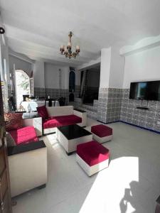een woonkamer met banken en een flatscreen-tv bij Magnifique Villa avec garage à 2min de la plage Saint-Rock, Ain El Turk, Oran in 'Aïn el Turk