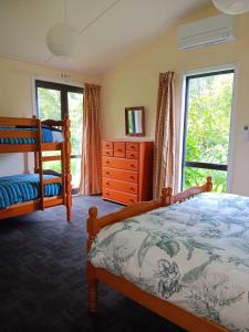 1 Schlafzimmer mit 2 Etagenbetten und einem Fenster in der Unterkunft Purple Hen Country Lodge in Katikati