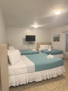 Habitación de hotel con 2 camas y TV de pantalla plana. en Posada La Hamaca, en Culebra