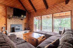 ein Wohnzimmer mit Sofas und einem TV in einer Hütte in der Unterkunft The Badger House in Badger