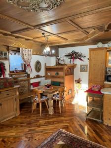 sala de estar con mesa y suelo de madera en Novità Booking a due passi dalla Ski Area en San Vito di Cadore