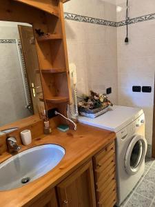 a bathroom with a sink and a washing machine at Novità Booking a due passi dalla Ski Area in San Vito di Cadore