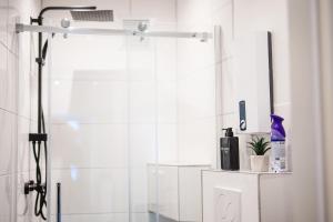 a white bathroom with a shower with a mirror at Uferzauber, Wohnung an der Schlachte, Innenstadt, Bremen in Bremen +5 photos