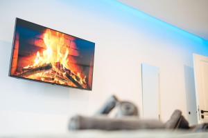 a living room with a fire under a tv at Uferzauber, Wohnung an der Schlachte, Innenstadt, Bremen in Bremen