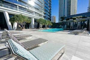 - une piscine dans un bâtiment avec des chaises longues dans l'établissement 3BR Circle On Cavill 52nd Floor Spacious Skyhome Apart, à Gold Coast