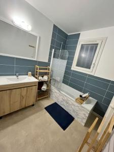 ein Badezimmer mit Badewanne, Waschbecken und Spiegel in der Unterkunft M&A maison de campagne/ Disney/Paris/Wifi/Jeux in Croissy-Beaubourg + 59 Fotos