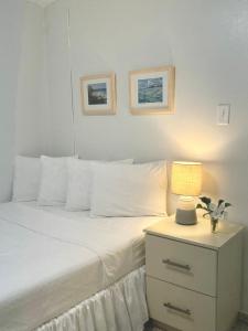 a bedroom with a white bed with a lamp on a night stand at Posada La Hamaca in Culebra