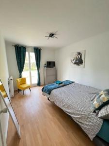 um quarto com uma cama e uma cadeira em M&A maison de campagne/ Disney/Paris/Wifi/Jeux em Croissy-Beaubourg