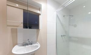 a white bathroom with a sink and a shower at Arlberg Hotel Mt. Buller in Mount Buller