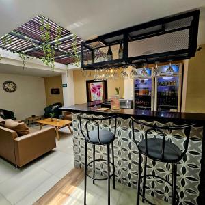 a bar with two stools in a living room at Laureles Guest House in Medellín