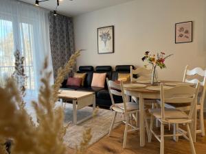 a living room with a table and a couch at Apartament NOWE POJEZIERZE in Olsztyn