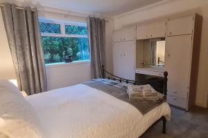 1 dormitorio con cama con espejo y ventana en Hebridean Country House en Lochs