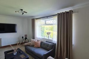 a living room with a blue couch and a window at Hebridean Country House in Lochs +13 photos