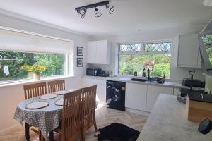 Hebridean Country House في Lochs: مطبخ مع طاولة ومغسلة وغسالة صحون