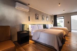 a hotel room with two beds and a couch at Hotel Expo Alcalá, a 1 min de Plaza del Sol in Guadalajara