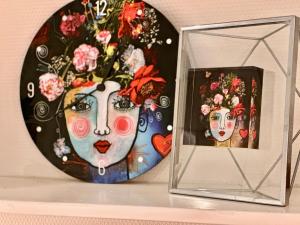 a mirror and a picture of a woman with flowers at Guesthouse Villa de Eikhof in Hengelo