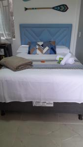 Una cama grande con cabecera azul en un dormitorio. en Pousada da Onça - Itapiranga, AM, en Itapiranga