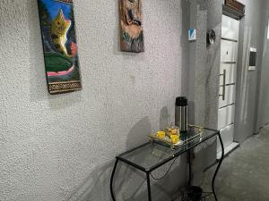 una mesa de cristal contra una pared con pinturas en la pared en Pousada da Onça - Itapiranga, AM, en Itapiranga
