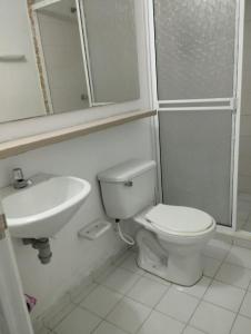 a white bathroom with a toilet and a sink at Apto de 3 habitaciones con ventiladores y parqueadero comunal in Valledupar