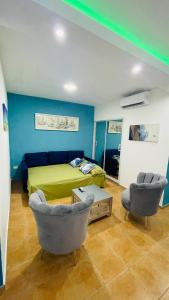 a bedroom with a green bed and two chairs at Promo_viviendas Sol y Mar in San Pedro de Macorís