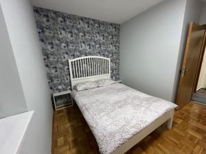a small bedroom with a bed and a wall at Apartman Obala in Bosanska Gradiška