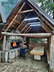 a log cabin with a fireplace and a wooden table at Vikendica Rajvosa Vlašić in Šišava