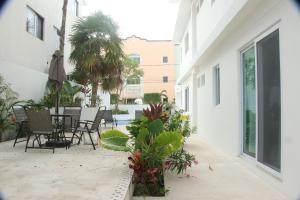 een patio met een tafel, stoelen en planten bij Edifico con departamentos amplios cerca de la playa in Puerto Morelos