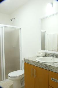 een badkamer met een toilet, een wastafel en een douche bij Edifico con departamentos amplios cerca de la playa in Puerto Morelos