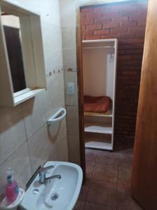 La petite salle de bains est pourvue d'un lavabo et d'un miroir. dans l'établissement Departamentos Urquiza, à Puerto Iguazú