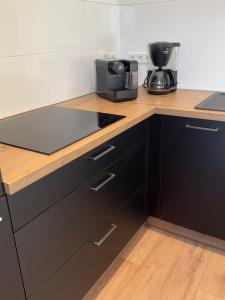 a kitchen with black cabinets and a counter top at Belm Ferienwohnung am Bach in Belm