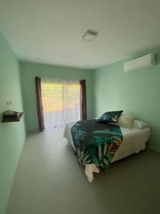 een slaapkamer met een bed in een kamer met een raam bij Casa Pacifico 46 Tamarindo in Santa Cruz
